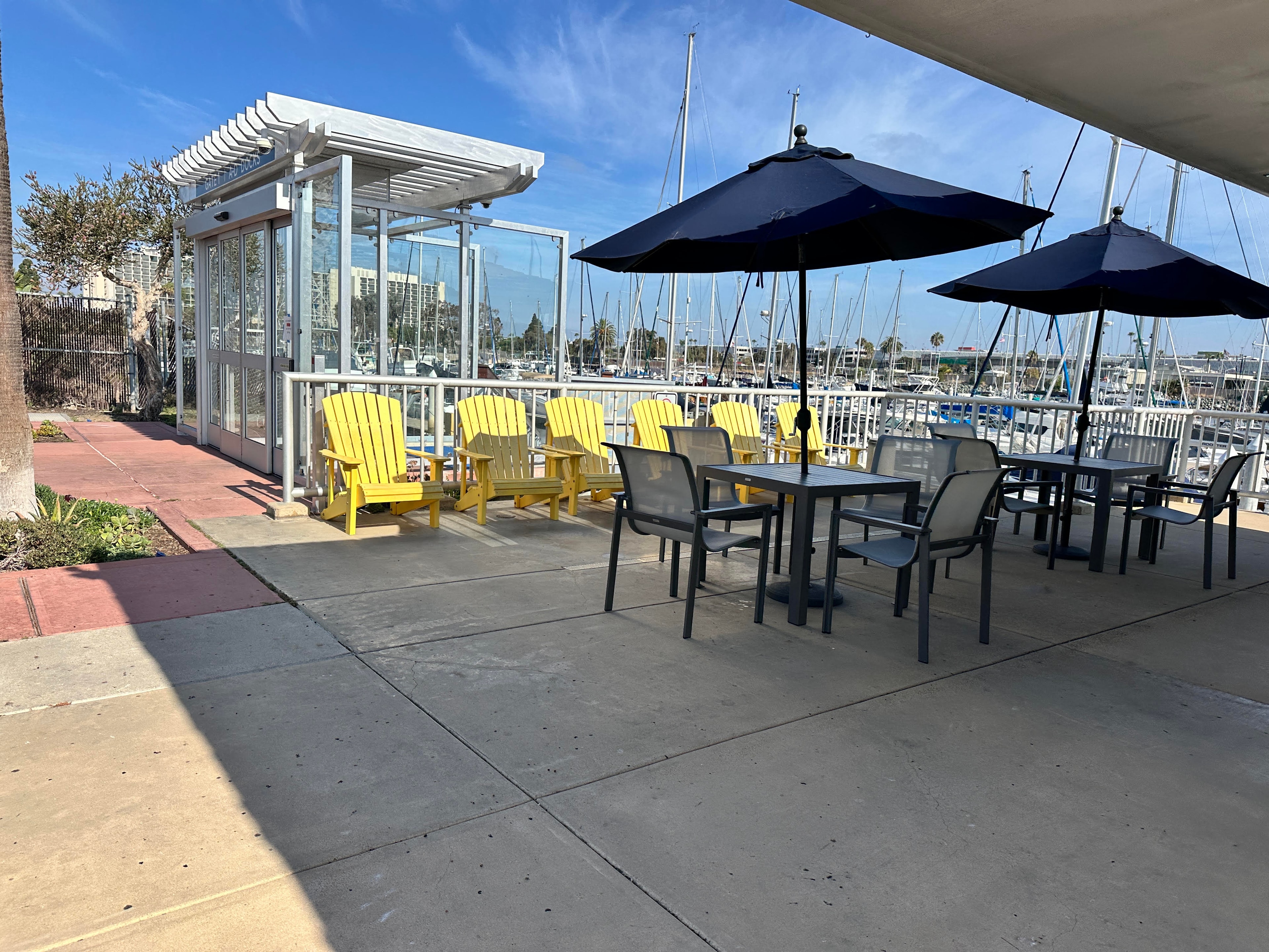 Marina patio at Gate 1 — yellow Adirondack chairs and outdoor seating overlooking Safe Harbor Sunroad Resort Marina