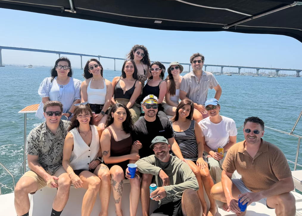 Group celebrating aboard a private yacht charter with Coronado Bridge in the background