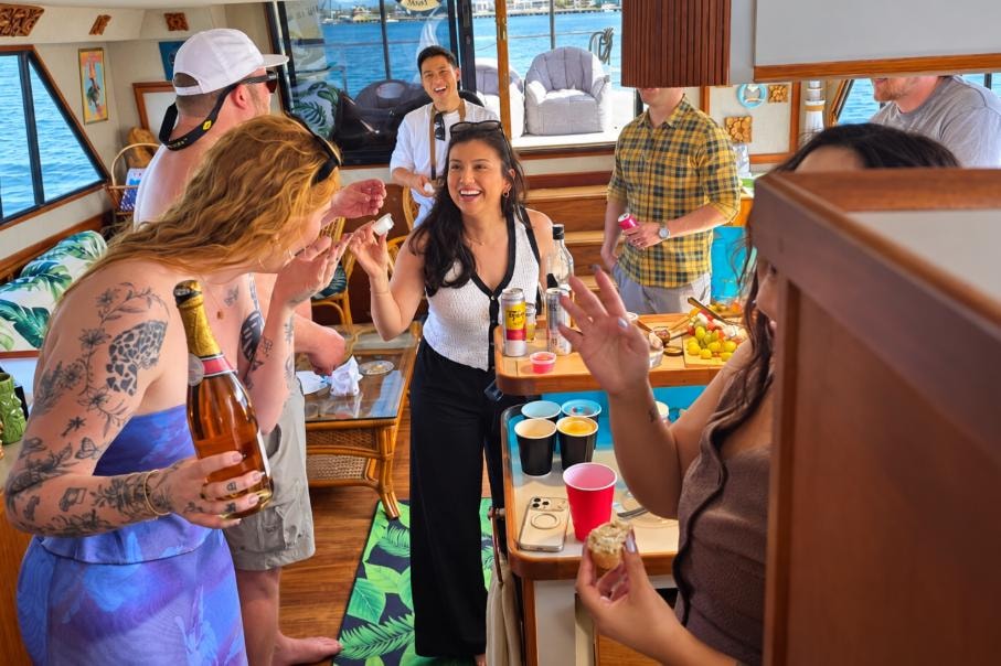 Group of friends socializing inside the Paradise Party Yacht cabin — private boat party San Diego Bay