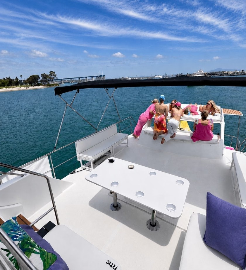 Private party boat San Diego — friends jumping off yacht into San Diego Bay during anchor and swim cruise