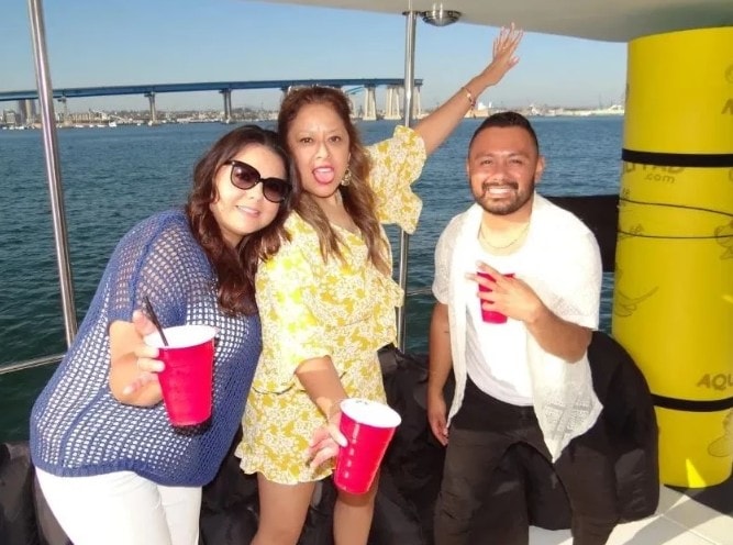 San Diego Bay yacht charter — friends celebrating with drinks on private boat with Coronado Bridge view