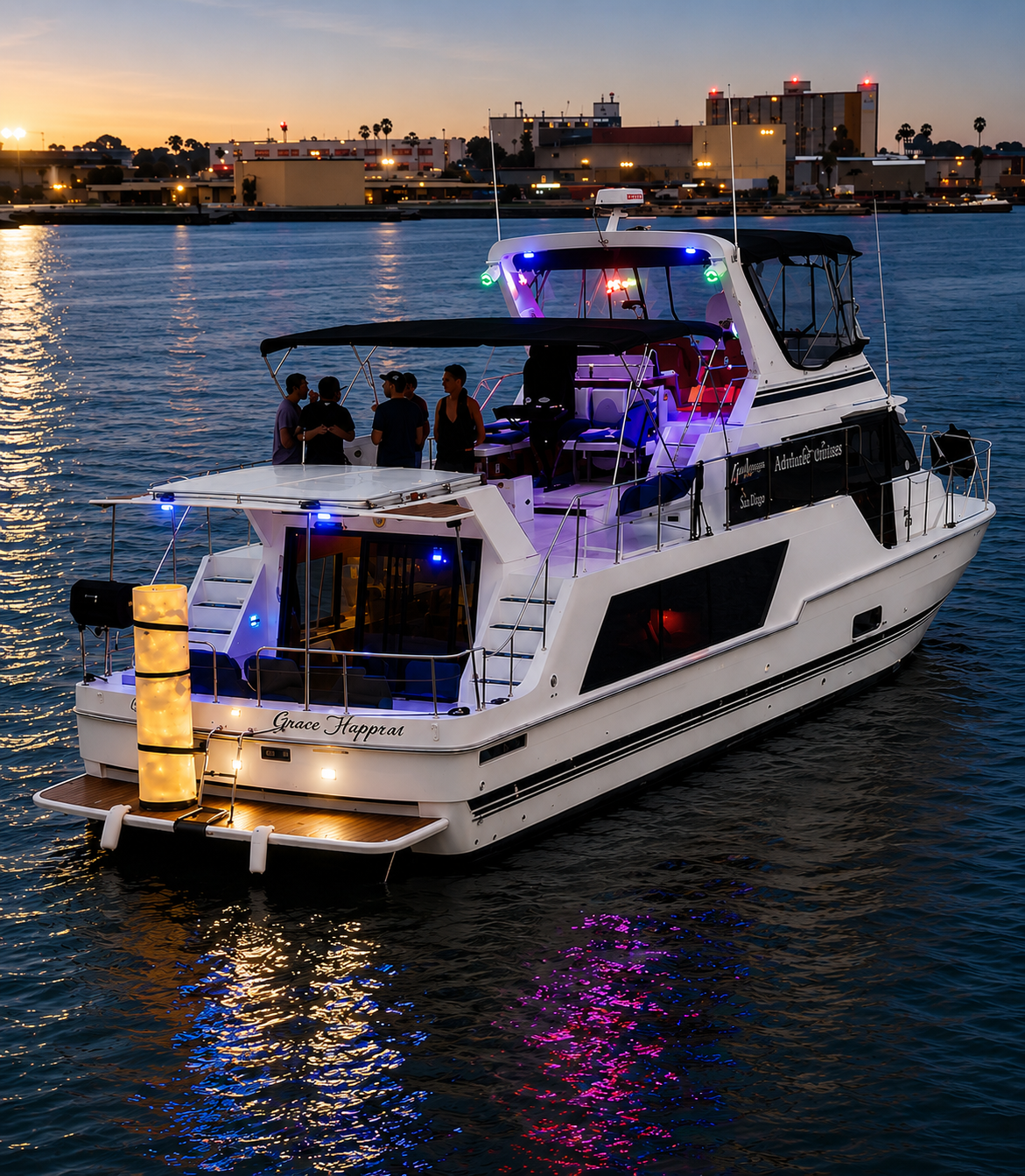 San Diego night cruise — private party boat lit up at dusk on the bay with city lights reflecting on water