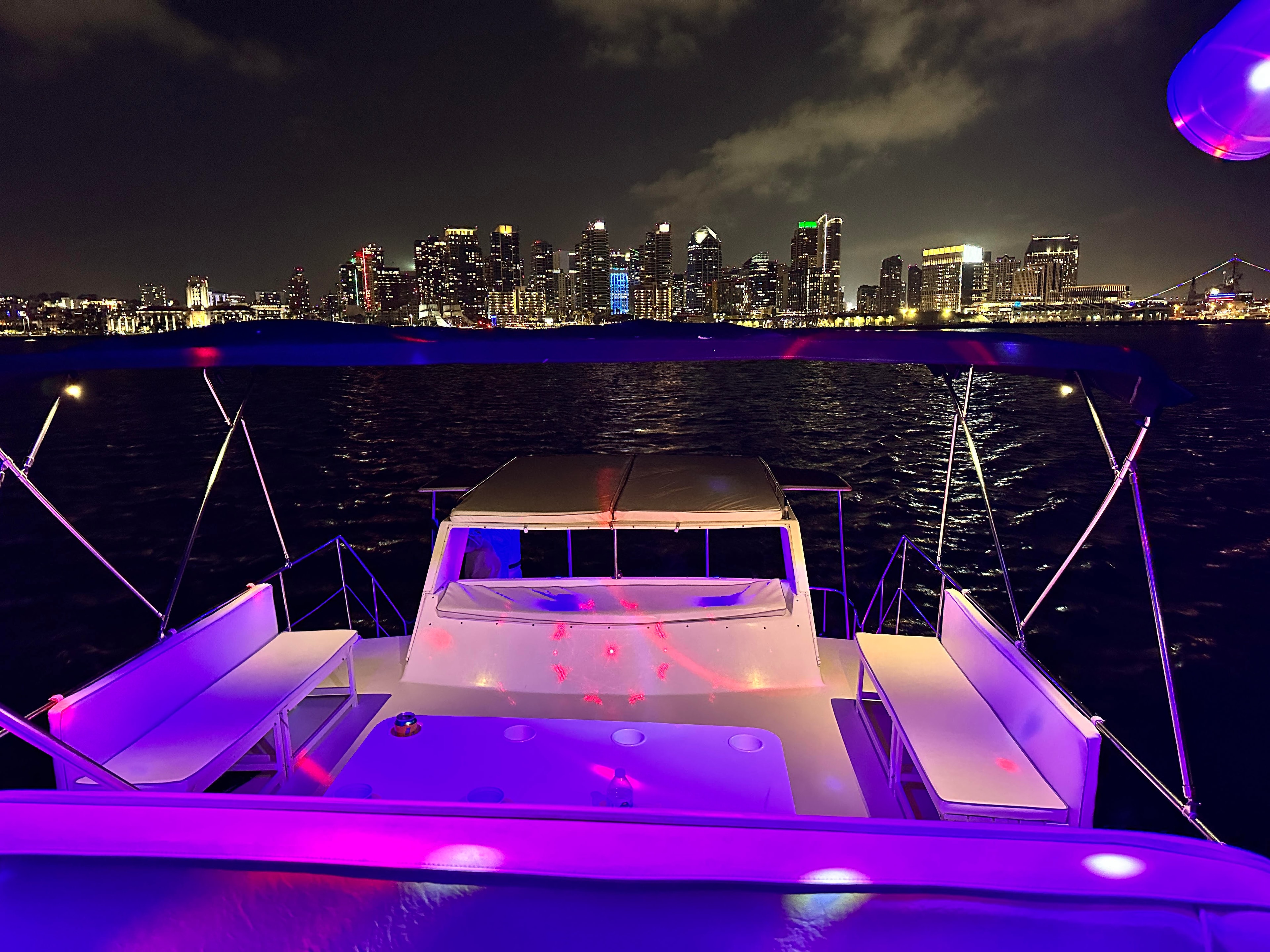 San Diego party boat night cruise — deck with party lighting and downtown skyline views on the bay