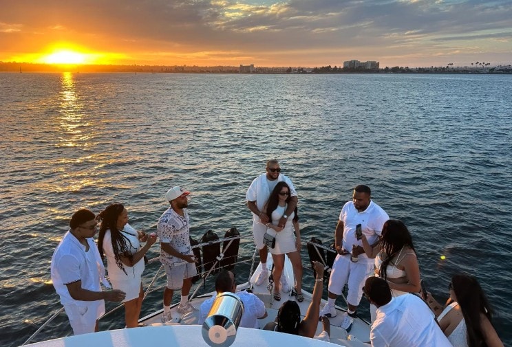 San Diego Bay sunset cruise — group celebrating on private party boat at golden hour on the bay
