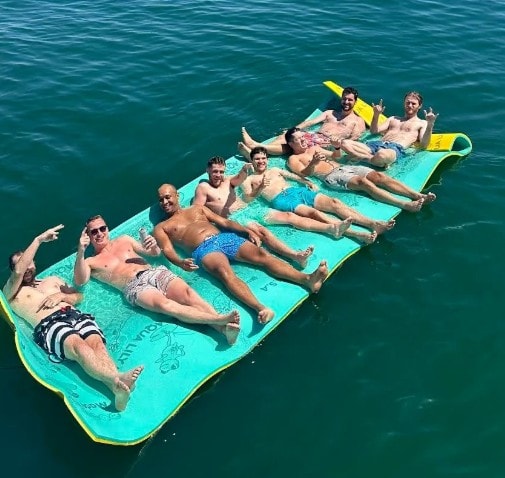 San Diego Bay yacht charter — guests lounging on lily pad float during anchor and swim cruise near Coronado