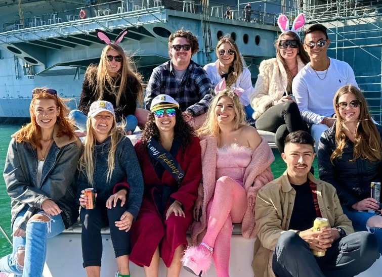 Bachelorette party boat San Diego — group posing on private yacht charter deck near USS Midway
