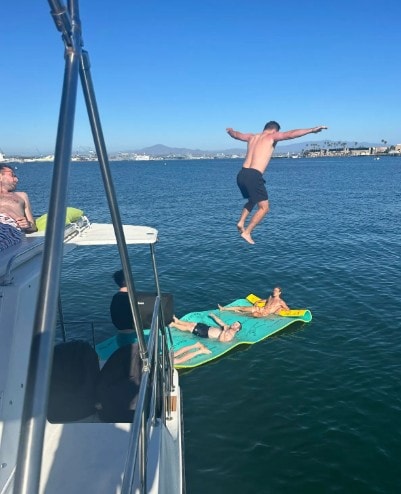 San Diego Bay anchor and swim — guest jumping onto lily pad float from private party boat