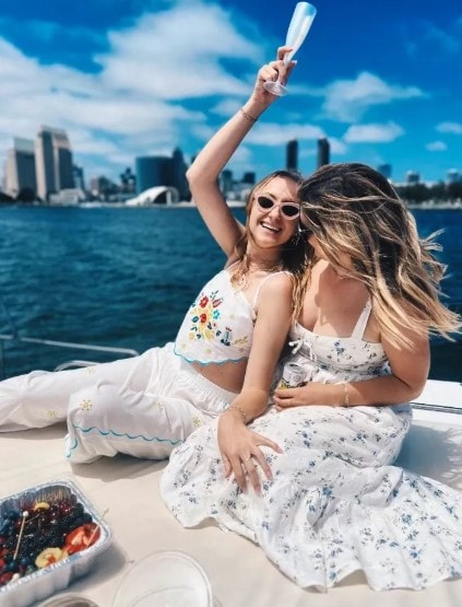 Women celebrating with champagne on San Diego party boat — private yacht charter with Coronado skyline