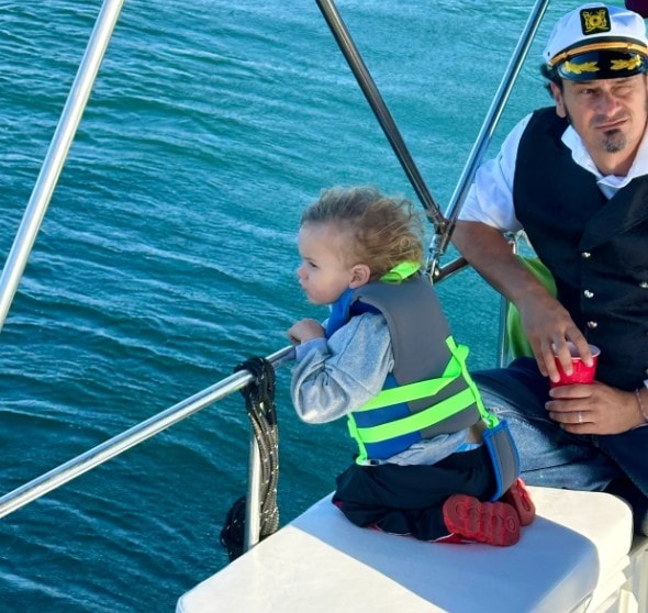 Family boat rental San Diego — child with captain on private yacht charter on San Diego Bay