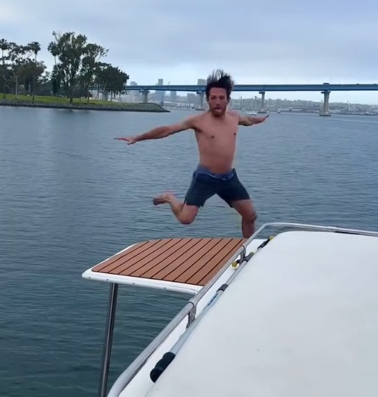 San Diego private yacht charter — guest jumping off swim platform into San Diego Bay during anchor and swim stop