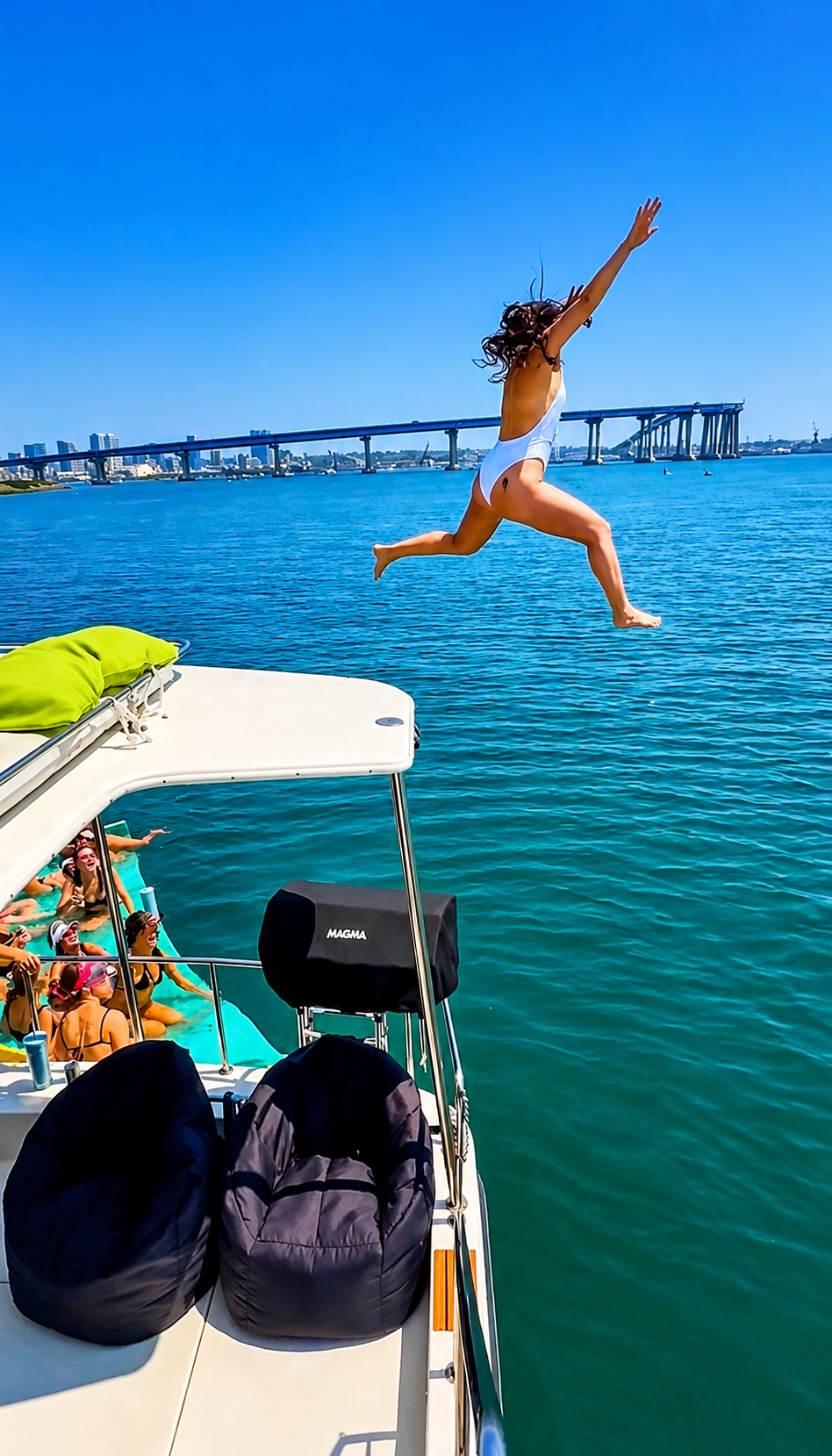 San Diego Bay anchor and swim cruise — guest jumping off private party boat near Coronado Bridge