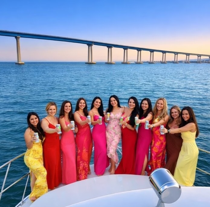 Private party boat San Diego — guests cheering on lily pad float during anchor and swim yacht charter
