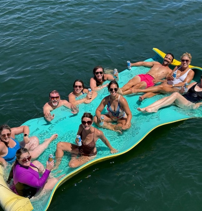 San Diego Bay anchor and swim cruise — group relaxing on lily pad float beside private yacht near Coronado