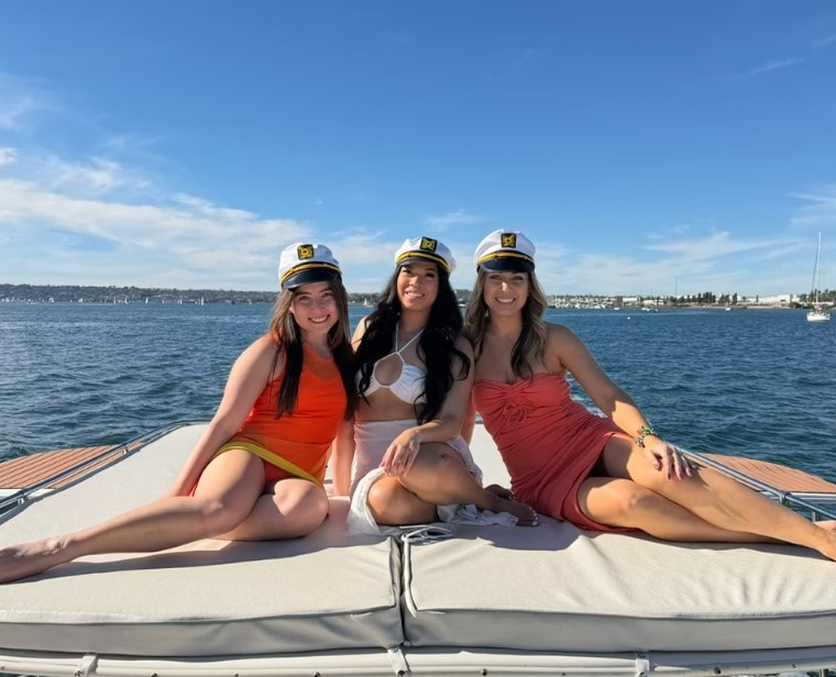 San Diego bachelorette party boat — three women in captain hats on private yacht bow on the bay
