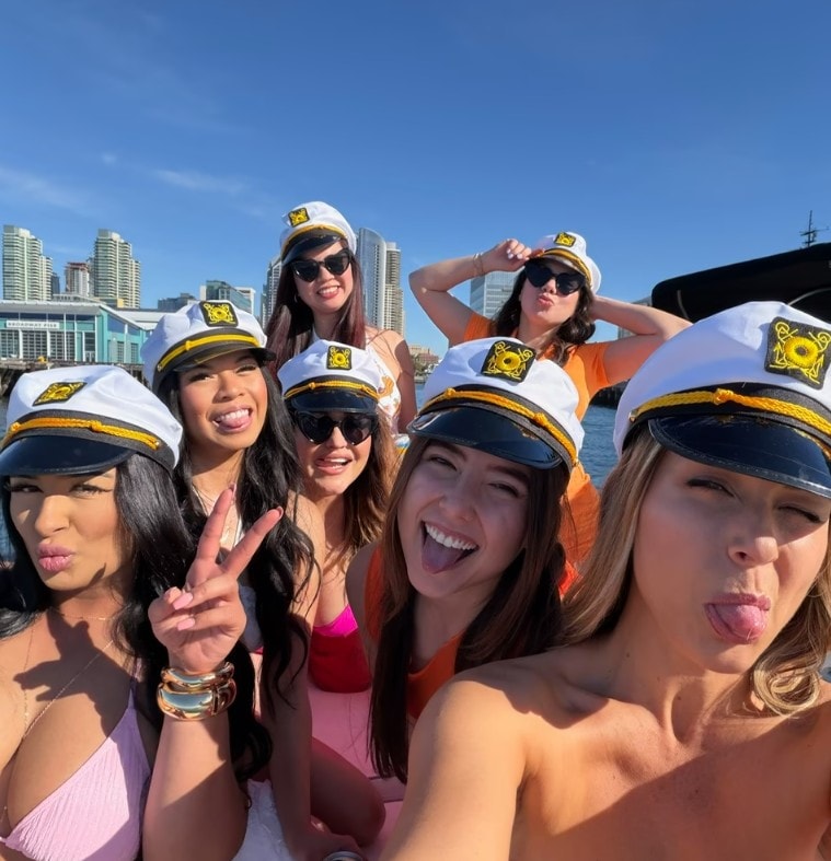 Bachelorette party boat San Diego — group of women in captain hats selfie on private yacht charter