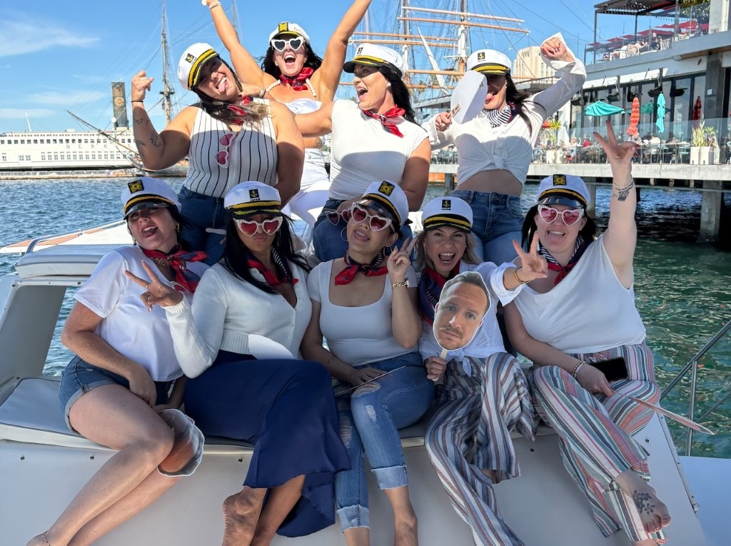 Bachelorette party boat San Diego — large group in sailor outfits on private yacht with Star of India backdrop