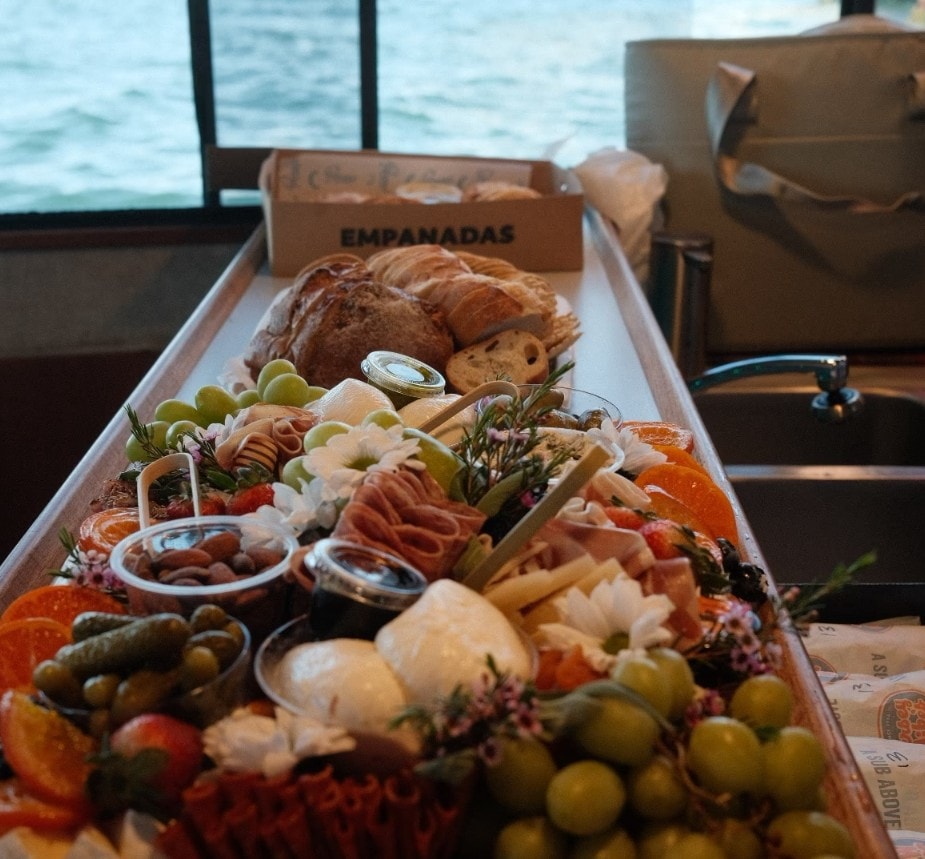 Private party boat San Diego — empanadas and charcuterie spread on catered yacht charter on San Diego Bay