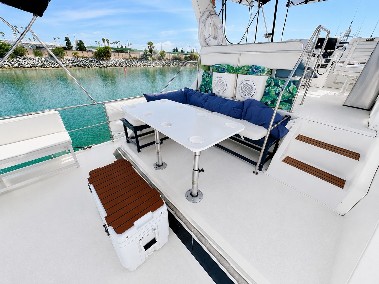 Yacht rear deck San Diego — aft seating area with table and blue cushions on the Paradise charter boat